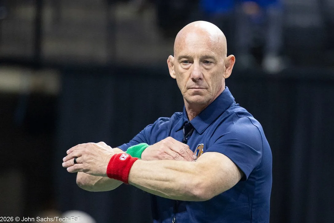 Dale Hanover stands with his arms crossed in a Full Circle Wrestling polo at a wrestling meet.